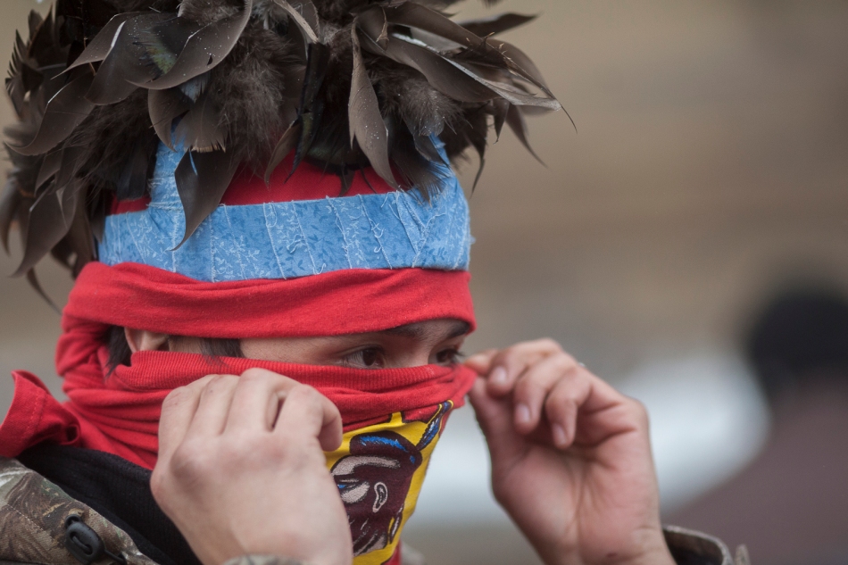 Ottawa, Ontario - A demonstrator adjusts his mask during an 'Idle No More' protest on January 11. The protest coincided with a working meeting between some First Nation's chief's and a ceremonial meeting with the Governor General.