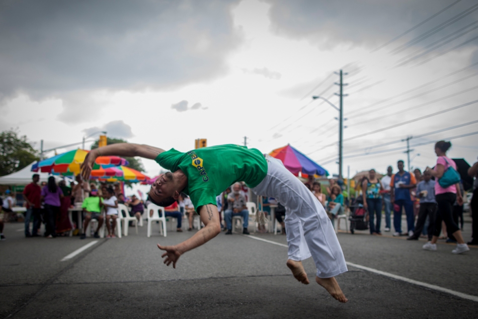 Jimmy 'Tosquia' Libaque performs a complex flip during a Capoeira performance at the taste of Lawrence Festival on Sunday.  Capoeira is a dance form and martial art developed by Brazilian slaves, traditionally each practitioner is given a nickname by their master, 'Tosquia' means 'to clip' in Portuguese and was a reference to the patterns Libaque would have shaved into his hair. (July 7, 2013)