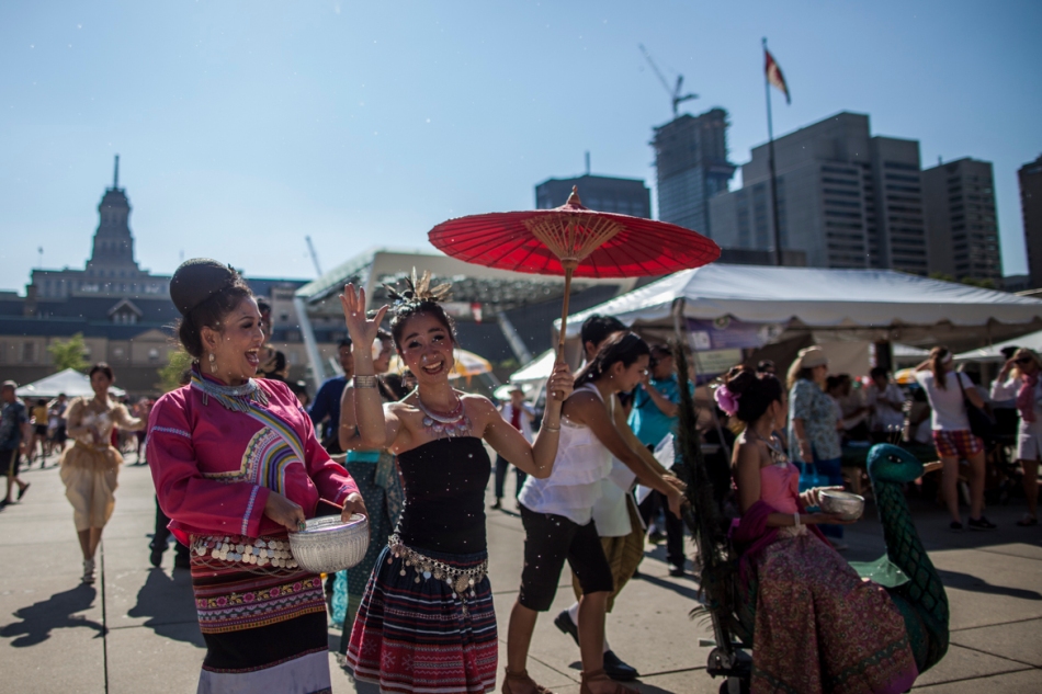 Performers at the Taste of Thailand + ASEAN Festival throw water at onlookers as they demonstrate a Thai new year celebration on Sunday at Nathan Phillips Square. (July 14, 2013)