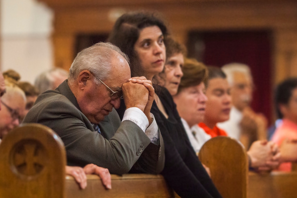 Parishioners pray during a mass celebrating the 100th anniversary of St. Clare's Catholic Church on Sunday.  The church marked it's centennial  with a solemn mass and and unavailing of a new statue of St. Clare. (August 11, 2013)