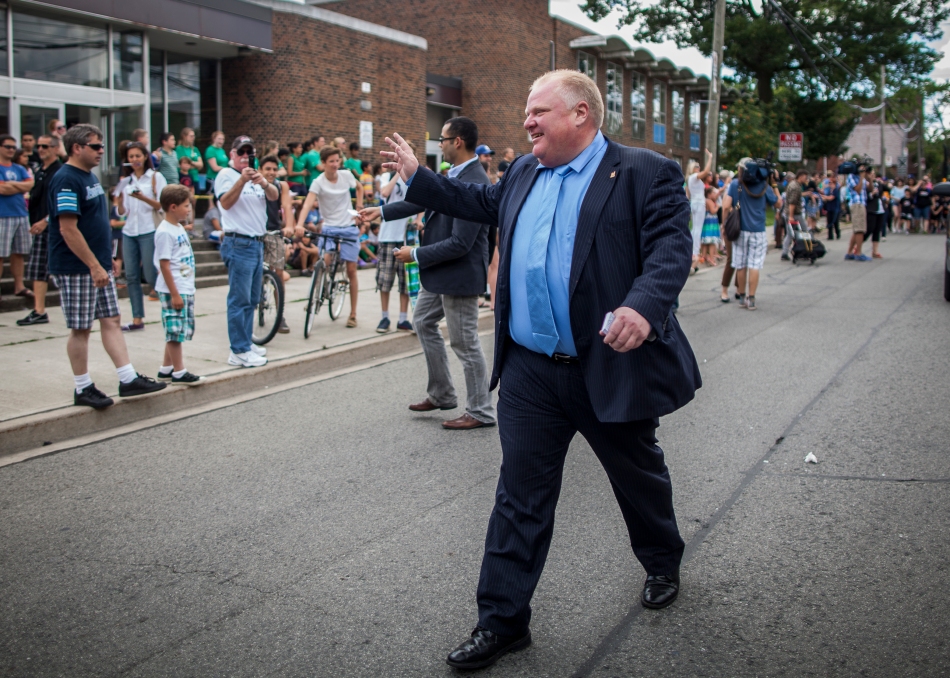 Mayor Rob Ford waves at people on Mimico Avenue as he leads the Stanley Cup Parade on Thursday.  (August 1, 2013)