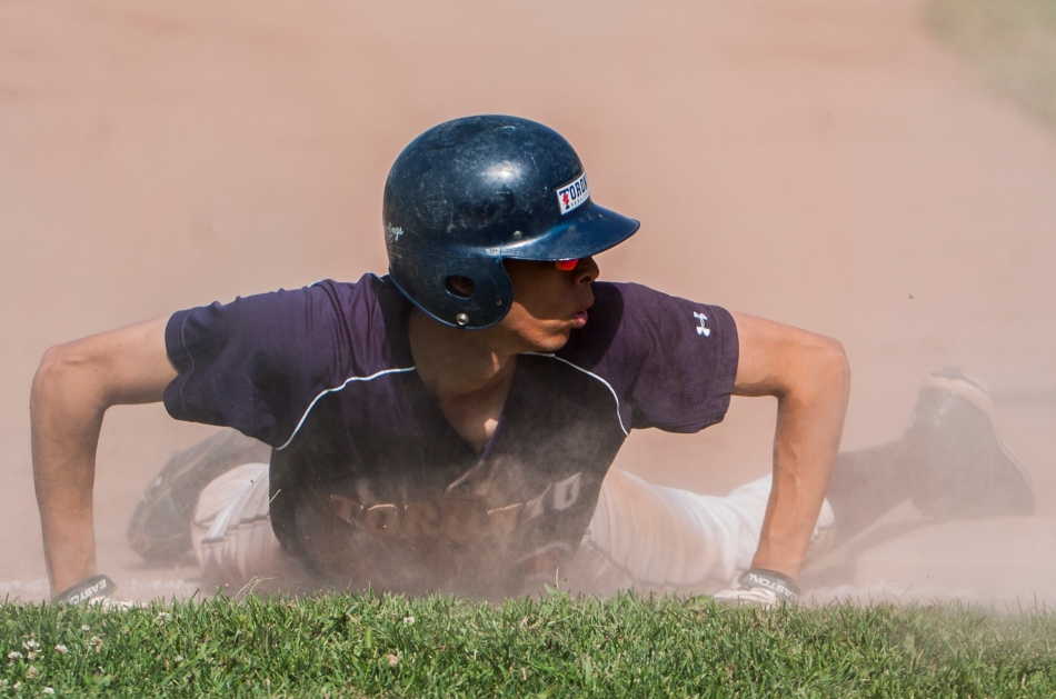 University of Toronto Varsity Blues' Oshima Yusuke checks for an umpires call after safely sliding into third base during an exhibition game against the University of Guelph Gryphons on Friday.  Toronto defeated Guelph 7-6. (August 23, 2013)