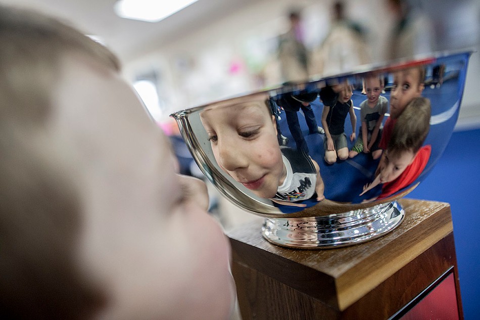 Austin Leadlay, 7, looks at his face reflected in the North West Junior Hockey League Senators Cup during a visit by three of the North Peace Navigators to the North Peace Gymnastics Club in Peace River Alberta on April 7, 2014. The Navs were at the DMI Endurance Centre to drop off a check for $7800 to pay the gymnastics club for providing security Parents of children at the gymnastics club worked as security at the Baytex Centre during Navigators home games in order to fundraise money for the gymnastics club this season. ADAM DIETRICH/RECORD-GAZETTE/QMI AGENCY
