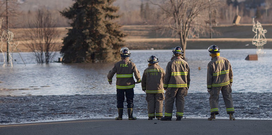 Firefighters from the Town of Peace River and the County of Northern Lights survey River Road, which had flooded, near Riverfront Park in downtown Peace River, Alberta after flooding occurred in areas around 98 Street and 100 Avenue on Tuesday April 8, 2014. According to authorities at the time the flooding seemed to be coming from a section of the Pat's Creek Culvert near that intersection. ADAM DIETRICH/RECORD-GAZETTE/QMI AGENCY