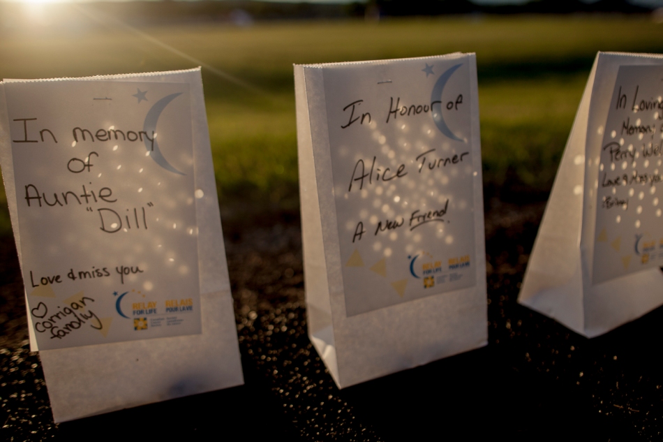 Luminaries, used as memorials by those who have been affected by cancer and bearing personal messages, are pictured next to the Glenmary High School track, during the Relay for Life on Friday, June 20, 2014 in Peace River Alta. The relay raised over $36,000 for cancer research. Adam Dietrich | Record-Gazette/QMI Agency