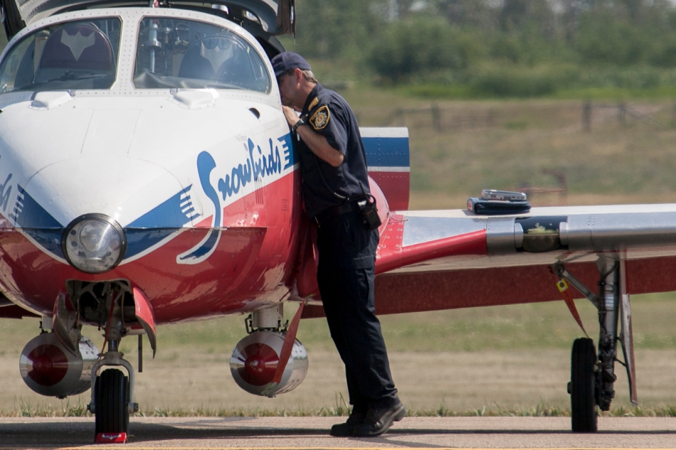 A Peace River firefighter checks out a RCAF Snowbird on display at the Peace Regional Air Show on Sunday, July 13, 201 in Peace River, Alta. Adam Dietrich | Record-Gazette/QMI Agency
