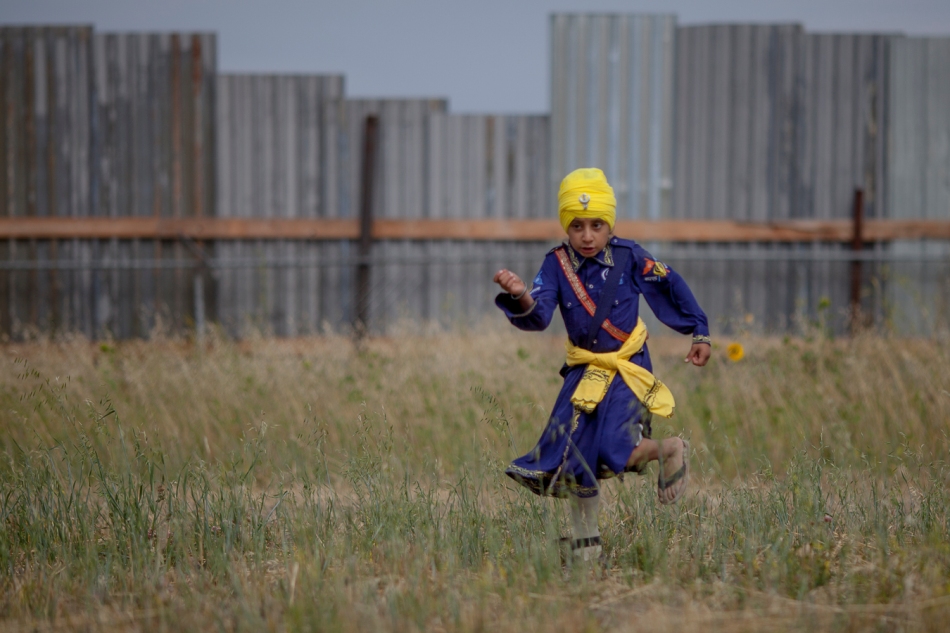 Parmdalip Goais runs through a field outside St. Isidore, Alta. during the Guru Nanak Shahi Langar celebration at Hilltop Auto Wreckers on Saturday, Aug. 23, 2014. The event is a Sikh religious and community event where a member of the community opens a free kitchen to the community. Sikhs from Alberta and B.C. came to celebrate. Non-Sikhs from the region also came out to join in the event, which was organized by Bill Singh Dhaliwal, who owns the auto wreckers. Adam Dietrich | Record-Gazette/QMI Agency